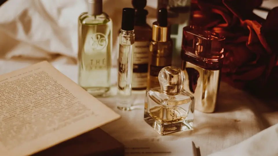 Opslået bog med parfumeflasker rundt om